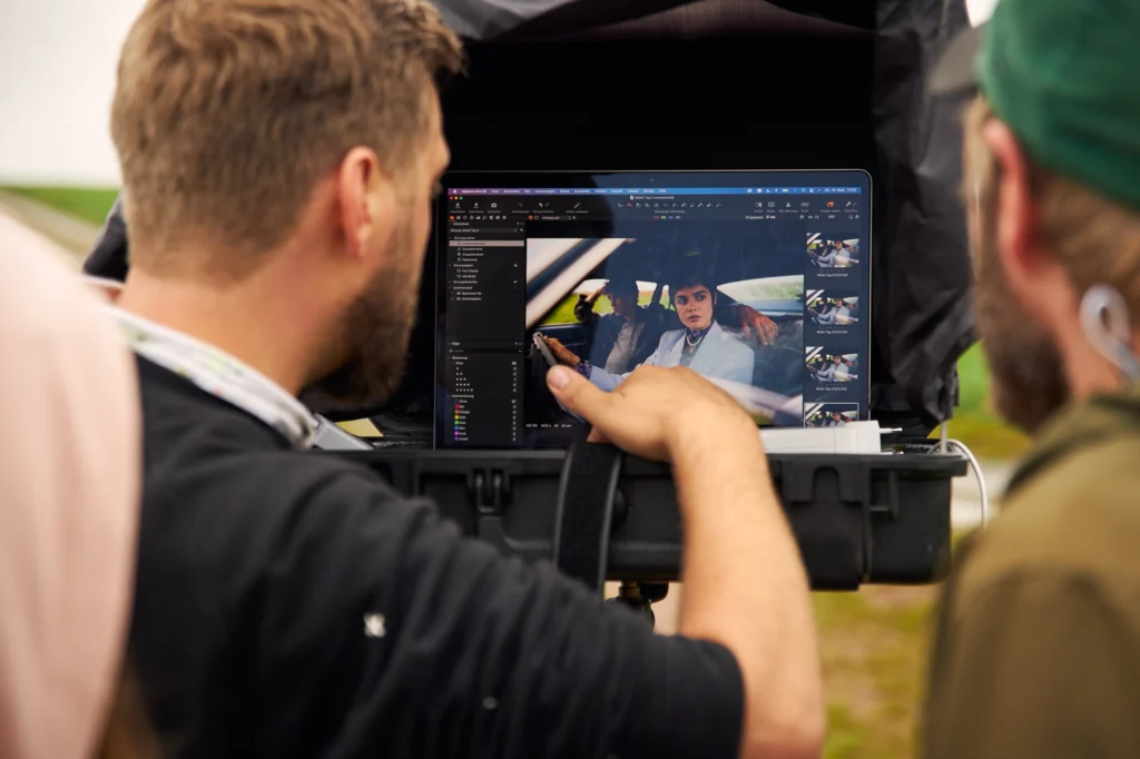 Fotograf schaut am Set seine geschossenen Fotos an